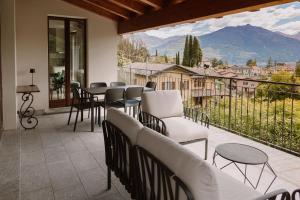a balcony with chairs and tables and a view of a mountain at Villa Elena in Menaggio