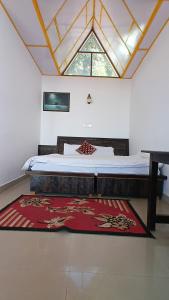 a bedroom with a bed and a red rug at DreamCatcher & Homestay in McLeod Ganj +52 photos