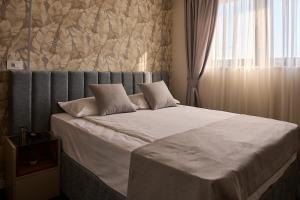 a bedroom with a large bed with a window at Garni Boutique Hotel Arta in Novi Sad +63 photos