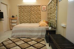 a bedroom with a bed with a blanket and a table at Studio 61 Saltlake Sector 1 Kolkata in kolkata
