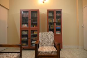 a room with a chair and book shelves at Studio 61 Saltlake Sector 1 Kolkata in kolkata
