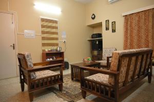 a living room with two chairs and a table at Studio 61 Saltlake Sector 1 Kolkata in kolkata
