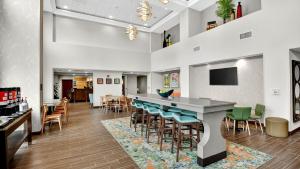 a bar in a restaurant with chairs and a table at Hampton Inn & Suites Chippewa Falls in Chippewa Falls
