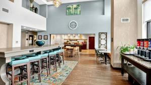 a bar in a restaurant with blue stools at Hampton Inn & Suites Chippewa Falls in Chippewa Falls