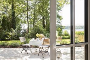 a dining room with a table and chairs looking out a window at Fischerkate - Ostholstein in Stocksee