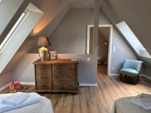 a attic room with a dresser with a lamp on it at Fischerkate - Ostholstein in Stocksee