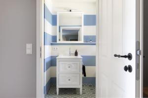 a bathroom with a white sink and blue and white stripes at Fischerkate - Ostholstein in Stocksee +21 photos