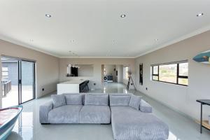 a living room with a couch and a kitchen at Grey Luxury Accommodation Langebaan in Langebaan
