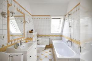 a bathroom with a tub and a sink and a toilet at Pächterhaus - Ostholstein in Manhagen +58 photos