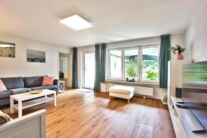 a living room with a couch and a tv at Ferienhaus Schreieck in Pöcking
