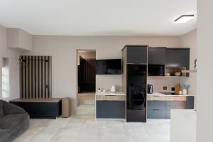 a kitchen with black appliances and a living room at Grey Luxury Accommodation Langebaan in Langebaan
