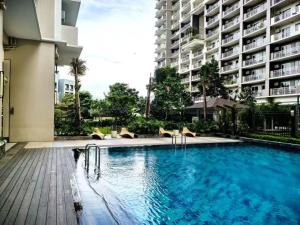 a large swimming pool in front of a building at Vtan Condo in Manila