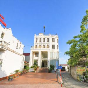 a white building with a staircase in front of it at Hotel Ngoc Anh - Van Don in Quang Ninh
