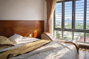 a bedroom with a bed and a large window at Hotel Ngoc Anh - Van Don in Quang Ninh