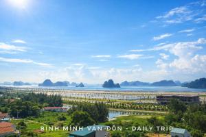 a view of the ocean with mountains in the distance at Hotel Ngoc Anh - Van Don in Quang Ninh