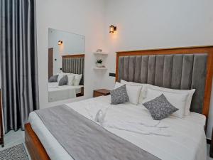 a bedroom with a large white bed and a mirror at Ceylon Vista in Galle