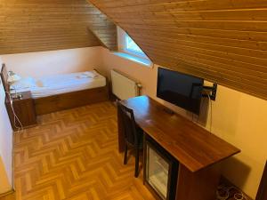 a room with a desk and a television and a bed at Juhász Fogadó in Fonyód