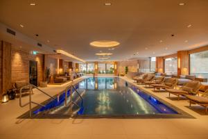 a pool in a hotel lobby with chairs and tables at Grand Hotel Zermatterhof in Zermatt