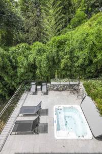 a hot tub on a patio with chairs and trees at Villa Elena in Menaggio