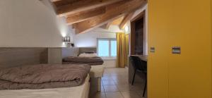 a bedroom with two beds and a desk and a window at Ostello Città di Rovereto in Rovereto +88 photos