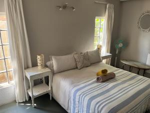 a bedroom with a bed with a teddy bear on it at Rapids View Cottage in Parys