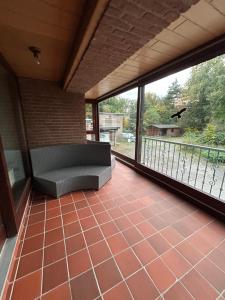 a screened in porch with a couch on a balcony at Heidezimmer in Bispingen