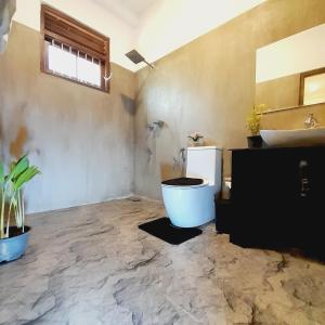 a bathroom with a toilet and a sink at Ashan Villa Ahungalla in Ahungalla