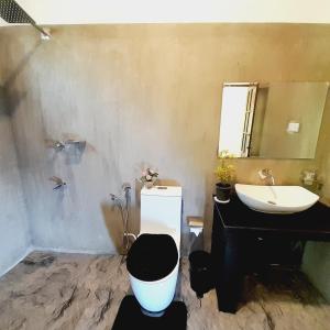 a bathroom with a black toilet and a sink at Ashan Villa Ahungalla in Ahungalla +15 photos