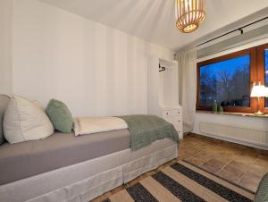 a bedroom with a bed with a window and a chandelier at Heidezimmer in Bispingen