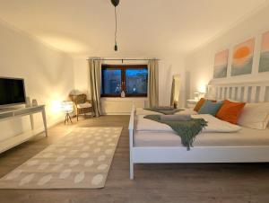 a bedroom with a white bed and a television at Heidezimmer in Bispingen