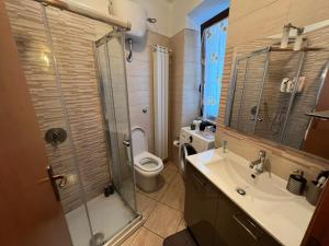 a bathroom with a toilet and a sink and a shower at Cassiopea in Isnello