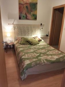 a bed with a green comforter in a bedroom at Casa do Caracol in Oliveira de Azemeis +28 photos