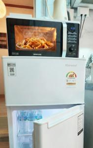 a microwave oven sitting on top of a refrigerator at Marine Mini House in Busan