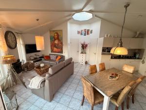 a living room with a table and a couch at Ferienhaus am Meer mit Kamin & Sauna - Seestern 251 in Julianadorp