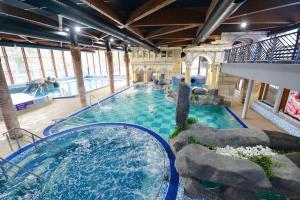 an indoor swimming pool with a water slide at Apartmani Sunny side sa otvorenim bazenom-besplatan parking in Vrnjačka Banja