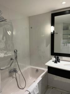 a bathroom with a bath tub and a sink at Lyon Marriott Hotel Cité Internationale in Lyon
