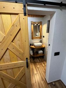 a bathroom with a wooden door and a sink at Mountain Chalet & Spa Makov Hrib in Makov Hrib