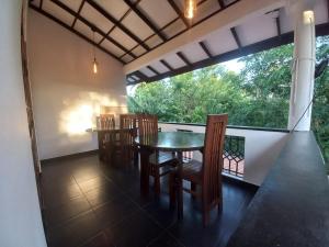 a dining room with a table and chairs on a balcony at Sethun House in Mirissa