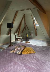 a bed with a purple comforter in a attic at Het Ambachtshuis Warffum in Warffum