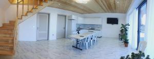 a kitchen with white walls and a wooden ceiling at Shahdag A-Frame in Qusar