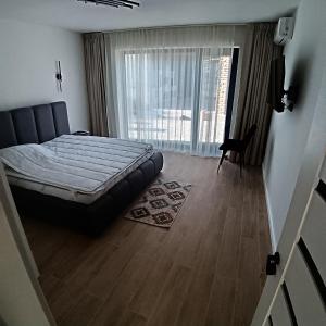 ein Schlafzimmer mit einem Bett und einem Holzboden in der Unterkunft Avabi Concept in Nenciu