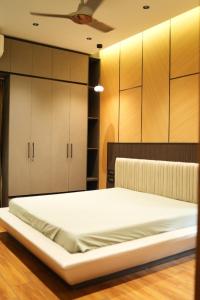 a bed in a room with wooden cabinets at Sharvin Villa in Karaikal