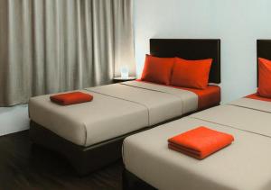 two beds in a hotel room with orange pillows at Intime Hotel Kuchai Lama Kuala Lumpur in Kuala Lumpur +12 photos