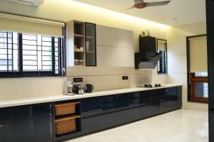 a kitchen with black and white counters and windows at Sharvin Villa in Karaikal