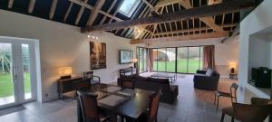 a living room with a table and chairs and a couch at Piscine - Domaine de Wolphus - 15 min de la mer in Zouafques