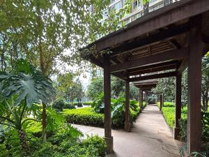 acovered walkway in a park with a building at Annie Apartment 3204 River View -only 120 meters from Metro Line 2 Exit of Chuanxinggulou in Kunming