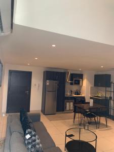 a living room with a couch and a table and a kitchen at One Bedroom Premium Luxury Apartments at The Embassy Garderns in Cantonments