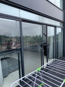 a glass house with a hammock on a balcony at One Bedroom Premium Luxury Apartments at The Embassy Garderns in Cantonments