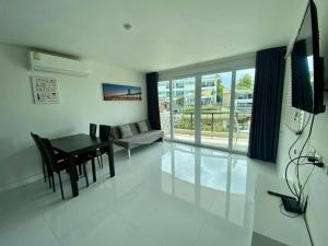 a living room with a table and a dining room at The nice condo 2 BR at Karon in Karon Beach