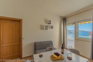 a room with a table with two glasses of wine at Sladana direct at the beach in Metajna